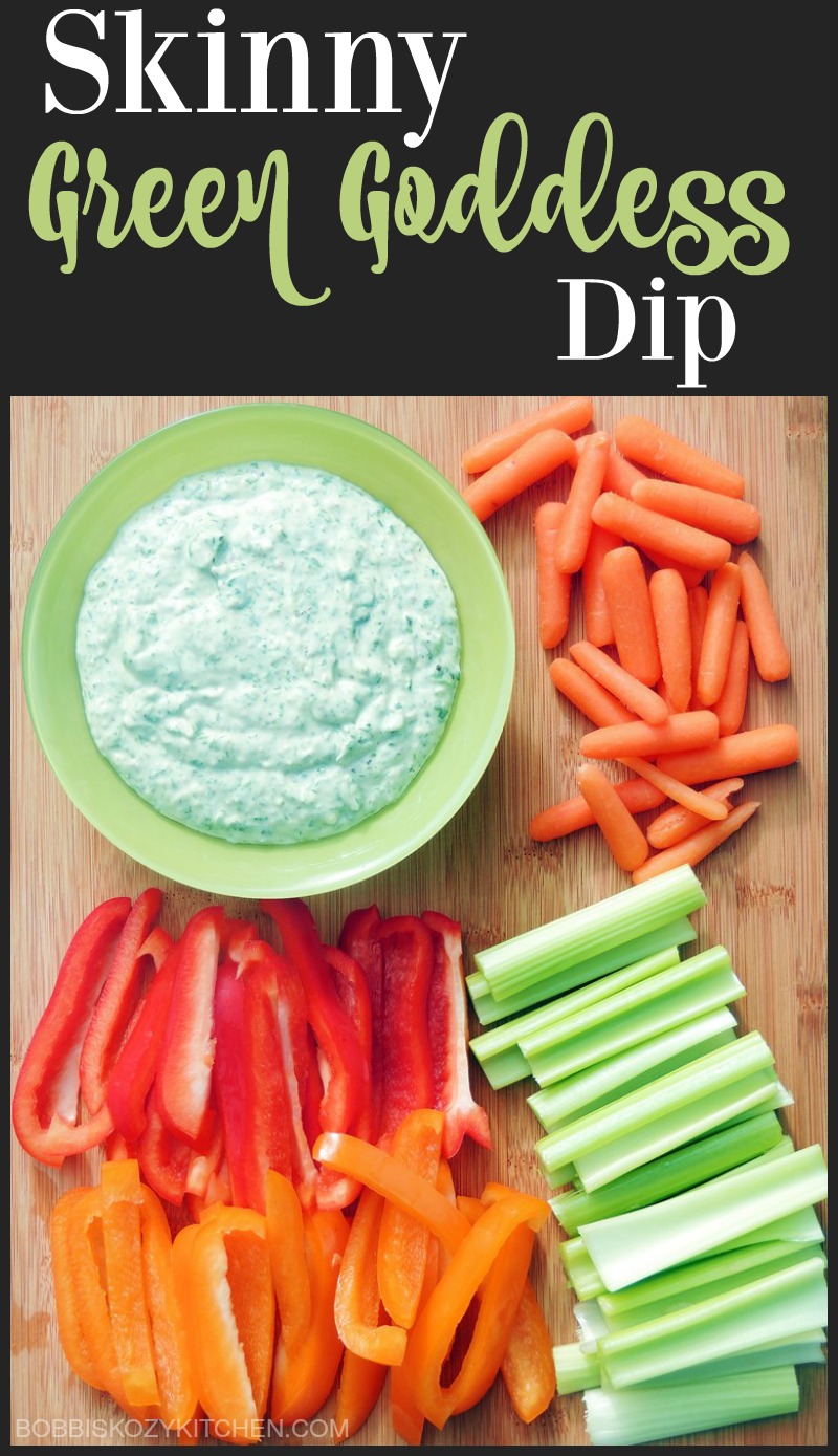 Skinny Green Goddess Dip in a green bowl with vegetables on a wooden board