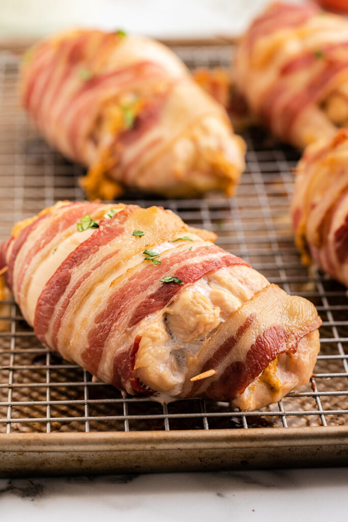 Bacon Wrapped Jalapeno Popper Chicken on a baking sheet just out of the oven.