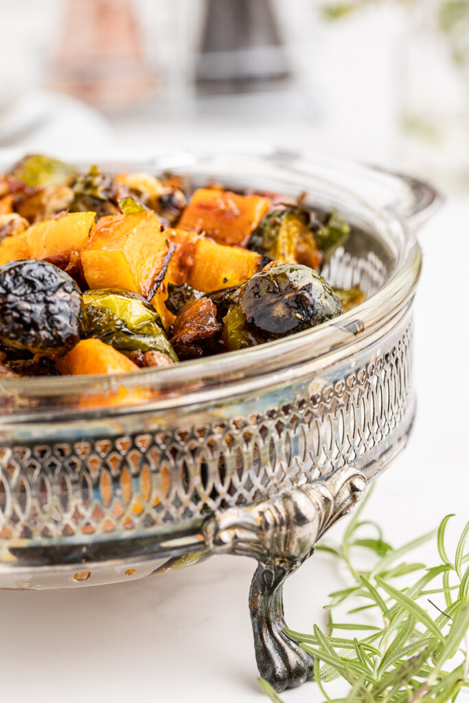 Keto Maple Roasted Brussels Sprouts and Butternut Squash in a glass serving dish.