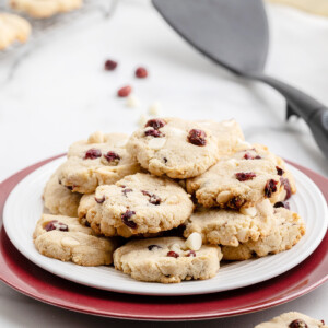 Several keto white chocolate cranberry cookies on a white plate.
