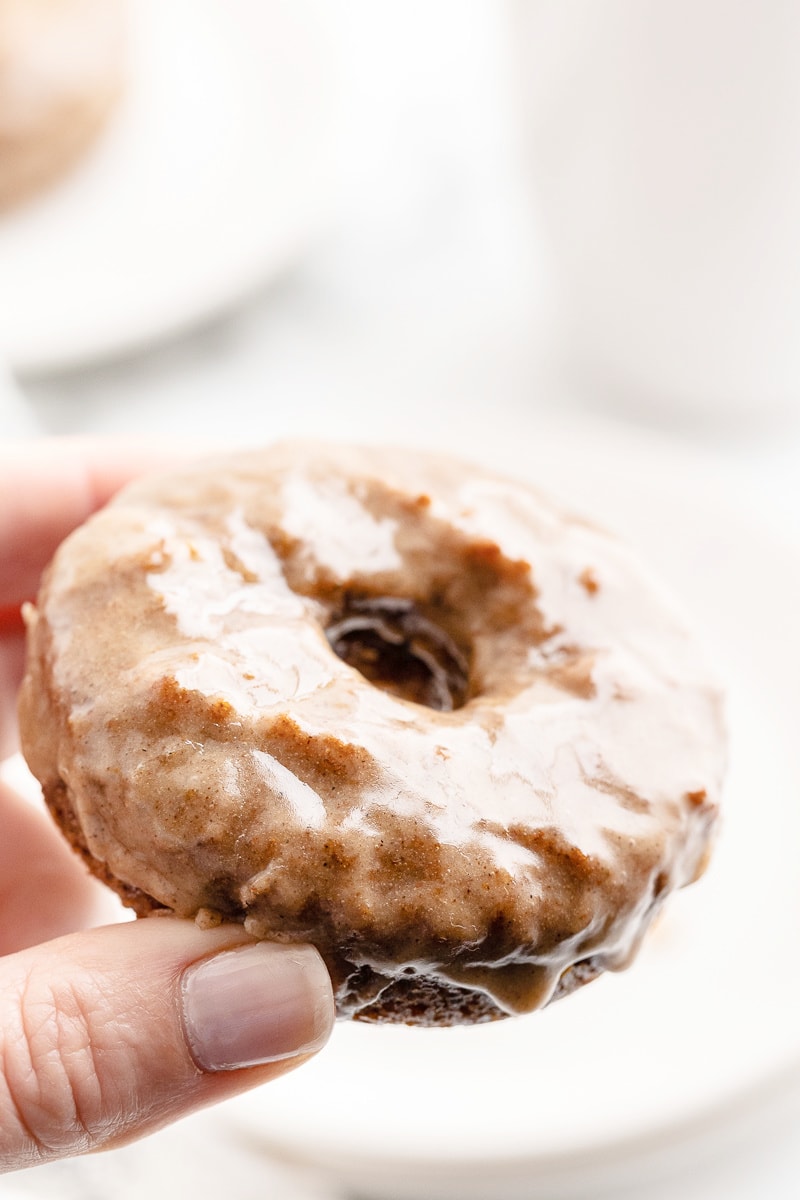 Close up of a white female presenting hand holding a keto chai donut.
