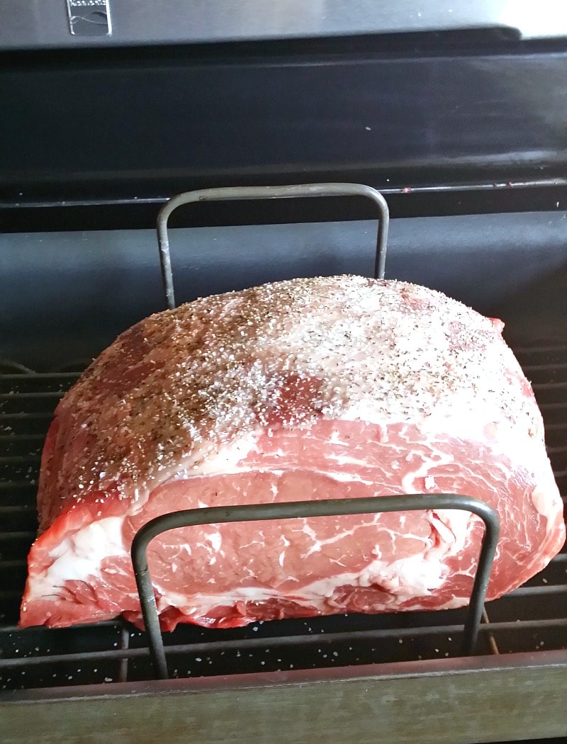Boneless beef rib roast with salt and pepper on it in a roasting pan.