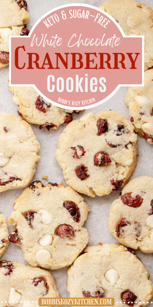 Image shows and overhead view of several Keto White Chocolate Cranberry Cookies on a parchment paper lined baking sheet.