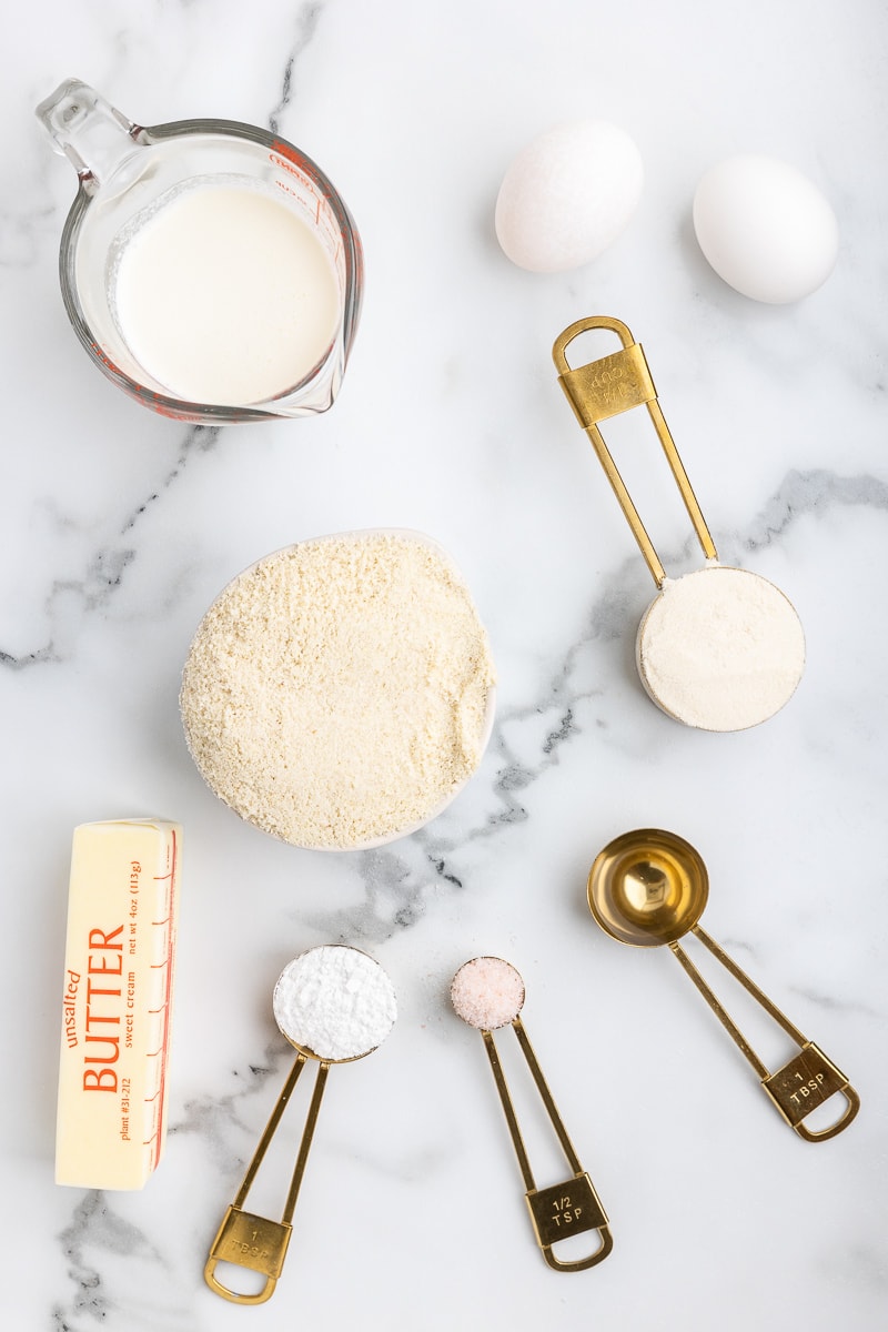 The ingredients needed to make keto buttermilk biscuits on a white marble counter.