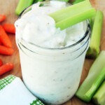 Creamy blue cheese dip and dressing in a mason jar with a celery stick.