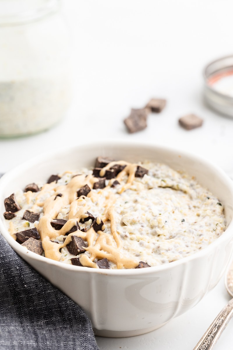 Keto Peanut Butter and Chocolate Oatmeal in a white bowl with a gray napkin and silver spoon.