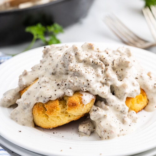 Keto sausage gravy and biscuits on a white plate.