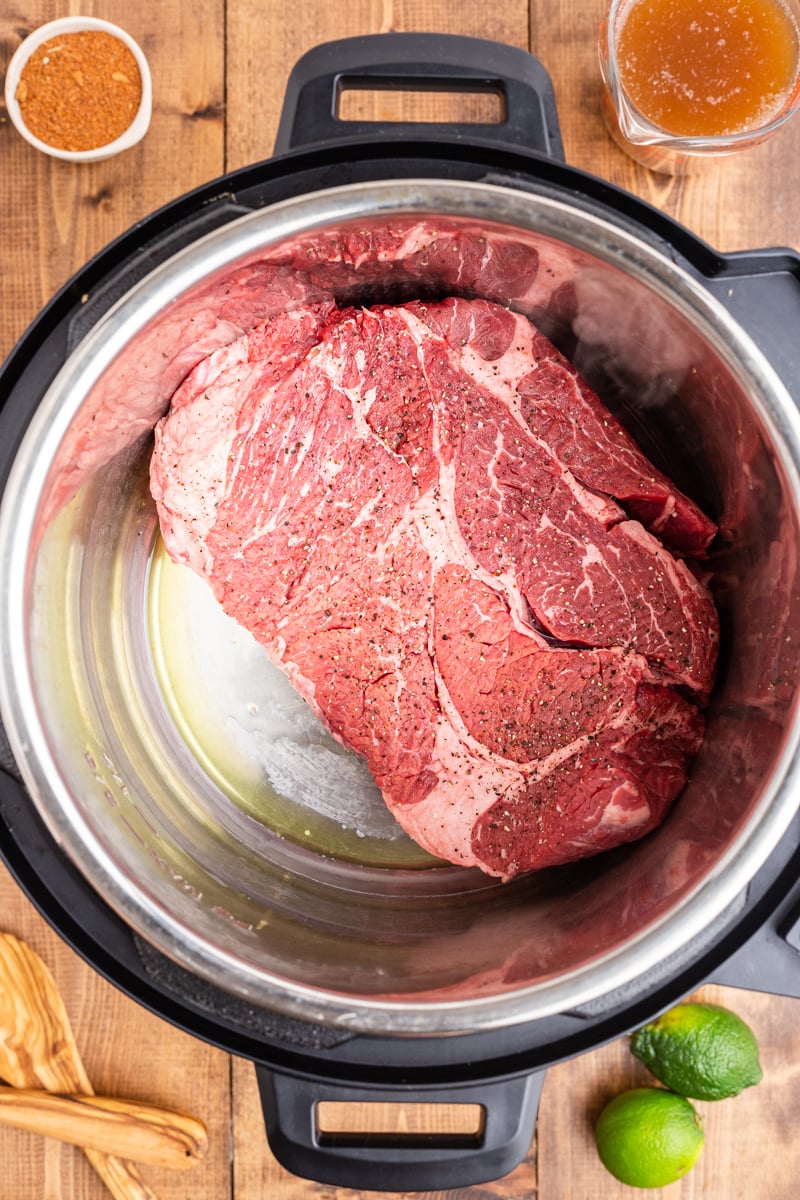 A beef chuck roast searing in an Instant Pot.