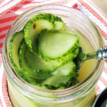 Closeup of Garlic Ginger Pickles in a glass jar with a silver spoon.