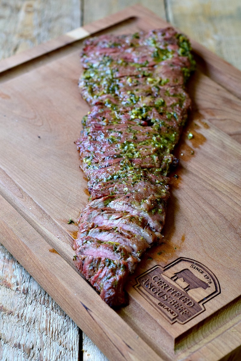 Fresh cooked carne asada sliced on a wooden cutting board.