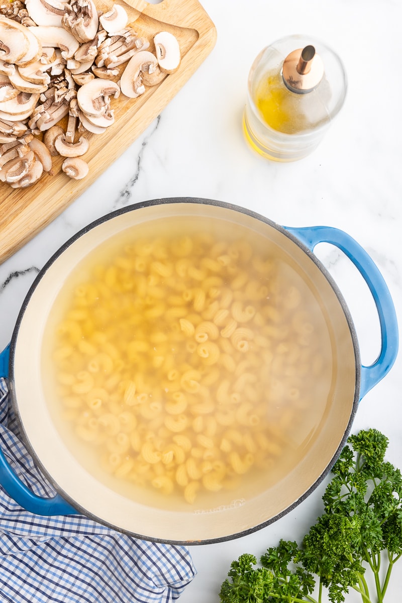 Low carb pasta boiling in a blue Dutch oven.