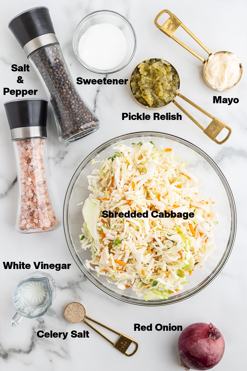 Overhead view of the ingredients need to make Dill Pickle Coleslaw on a white marble counter.