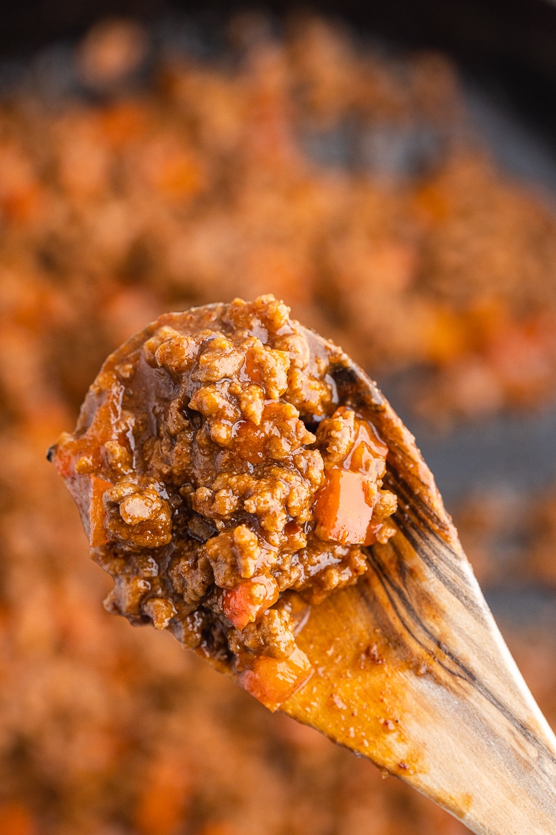 Irresistible Keto Sloppy Joes - Extreme close-up of a wooden spoon holding the rich deep red keto sloppy joe mixture. An inviting and flavorful low-carb meal that promises delicious satisfaction.