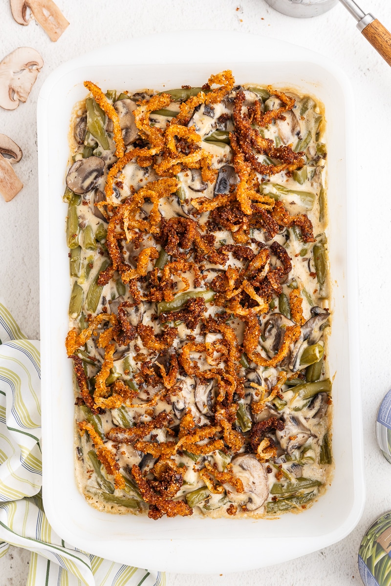 Overhead view of keto green bean casserole in a white baking dish on a white counter.