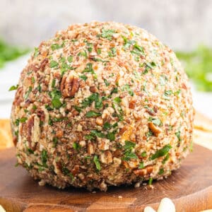 Closeup of a keto bacon ranch cheese ball on a wooden cutting board.