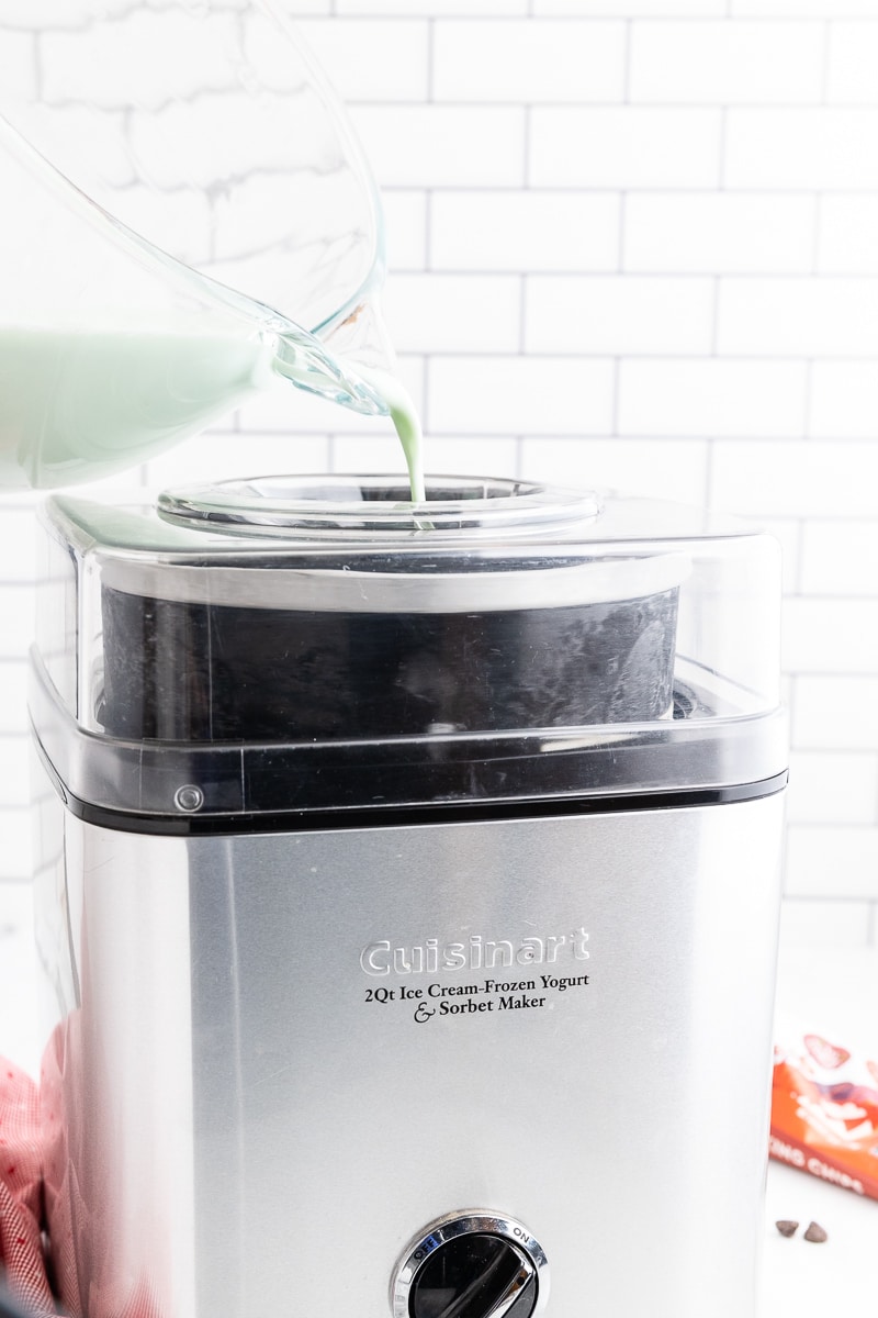 Keto mint chocolate chip ice cream base being poured into an ice cream maker.
