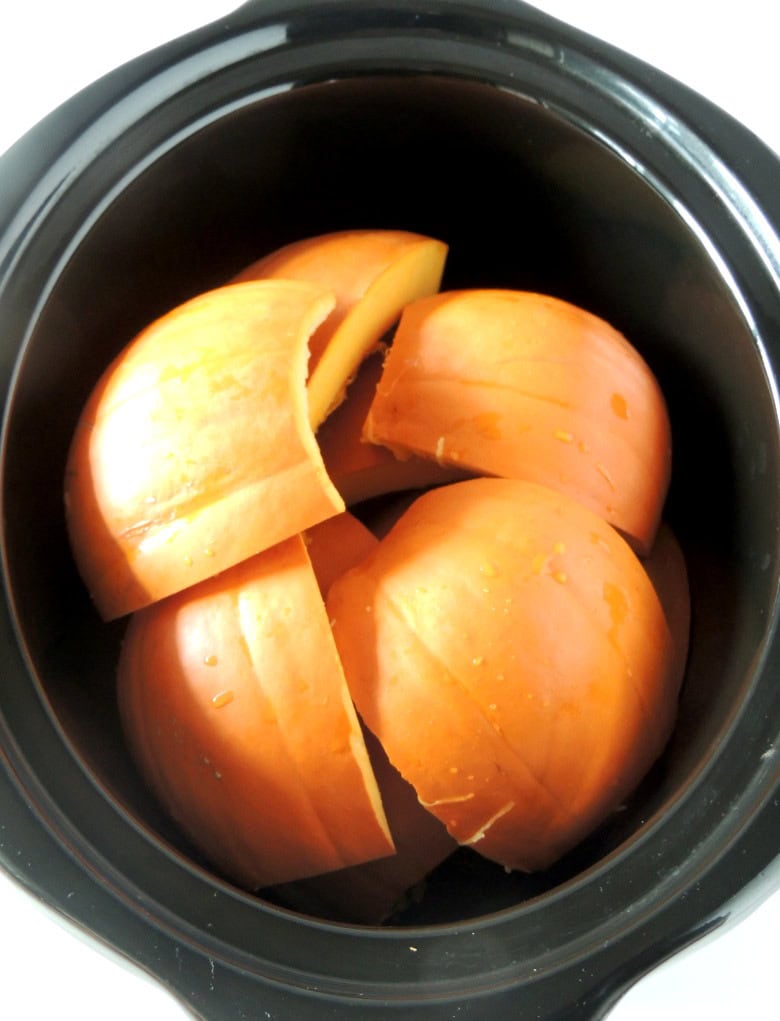 Pieces of raw sugar pumpkin in the bowl of a slow cooker.