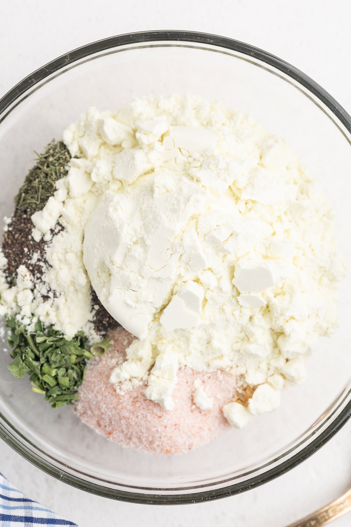 Closeup view of all of the ingredients needed to make homemade ranch dressing mix in a glass bowl.