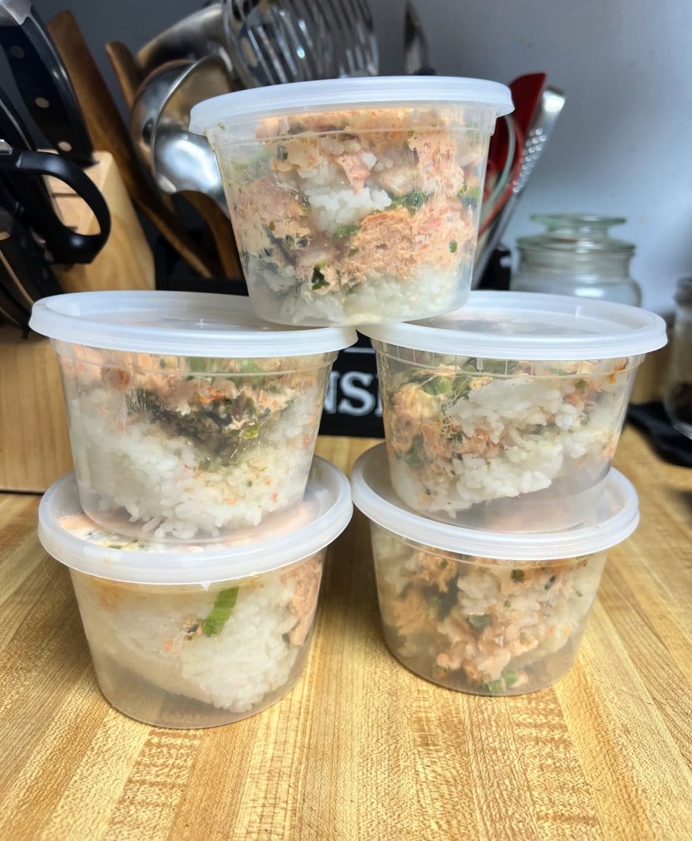 Five 16 ounce plastic restaurant containers holding individual servings of sushi bake for storage.