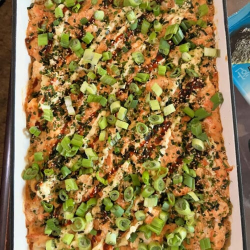 Overhead view of a shrimp and salmon sushi bake in a cream enameled cast iron casserole dish.