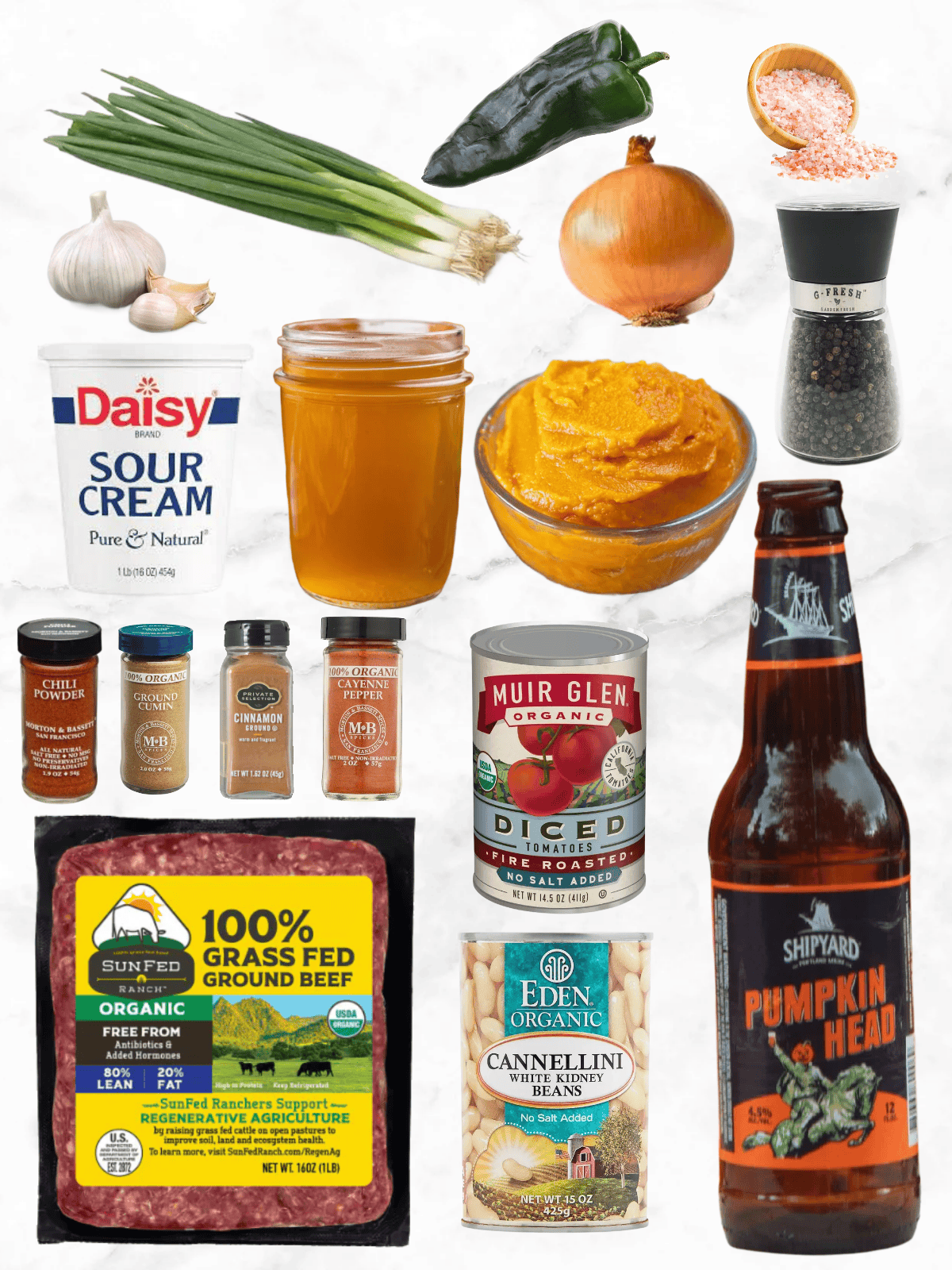 all of the ingredients needed to make pumpkin chili on a white marble background.